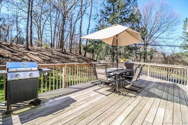 deck with outdoor dining space and a grill