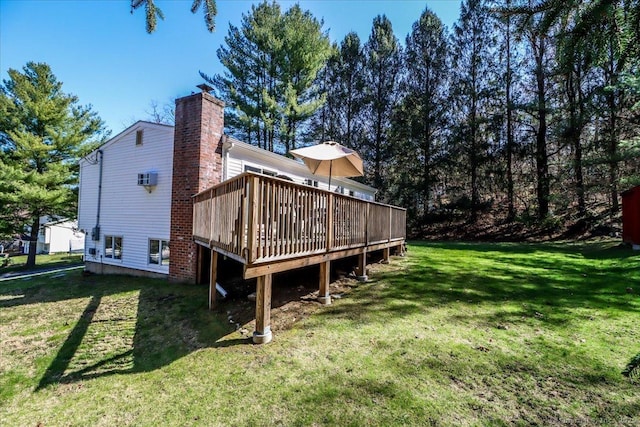 back of house featuring a wooden deck, a yard, and a chimney