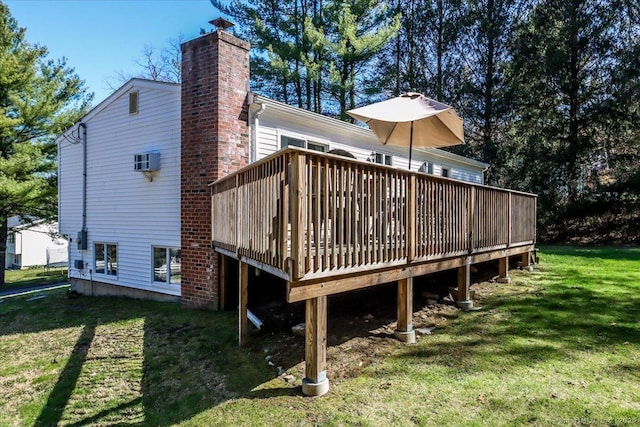 rear view of house with a chimney, a yard, and a deck