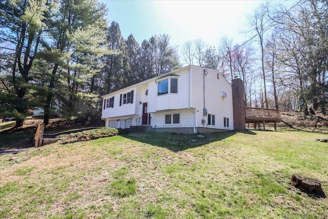 view of front facade with a chimney, a front yard, a deck, and a garage