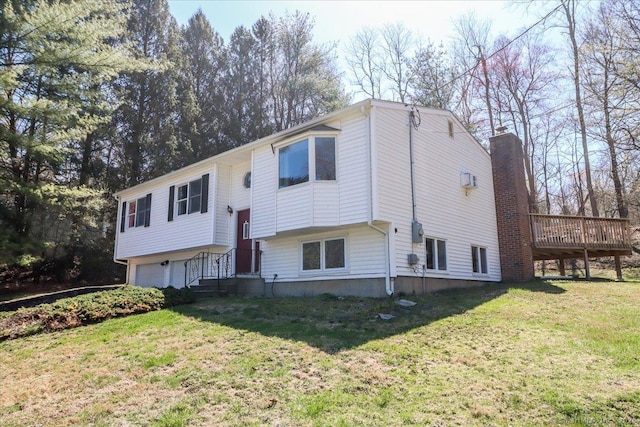 split foyer home featuring a garage, a chimney, and a front yard