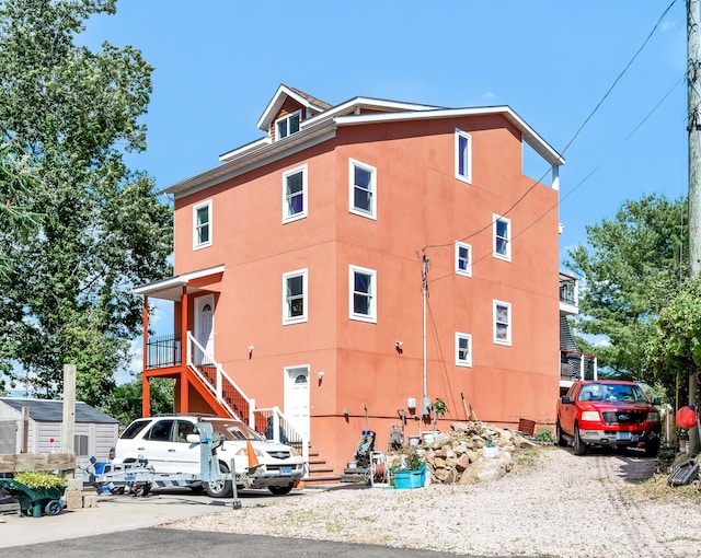 view of side of property featuring stucco siding and stairway