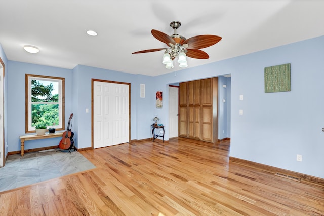 entryway featuring light wood-type flooring, baseboards, and ceiling fan