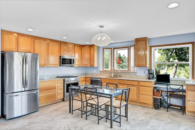 kitchen featuring recessed lighting, stainless steel appliances, a sink, light stone countertops, and pendant lighting