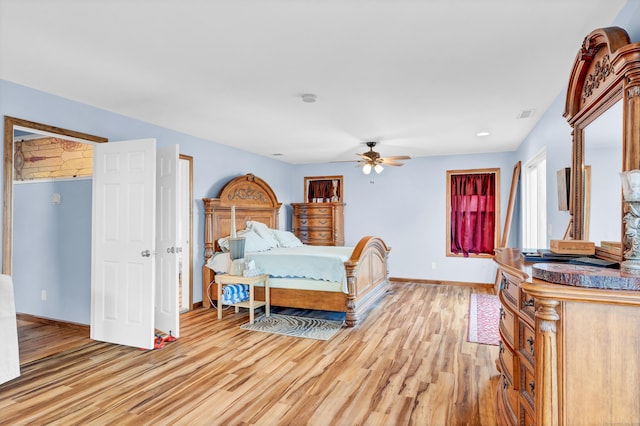 bedroom with visible vents, light wood-style flooring, baseboards, and a ceiling fan