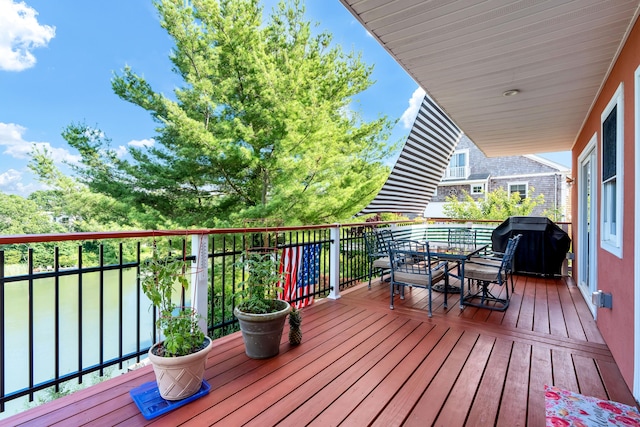 wooden terrace featuring grilling area and outdoor dining area