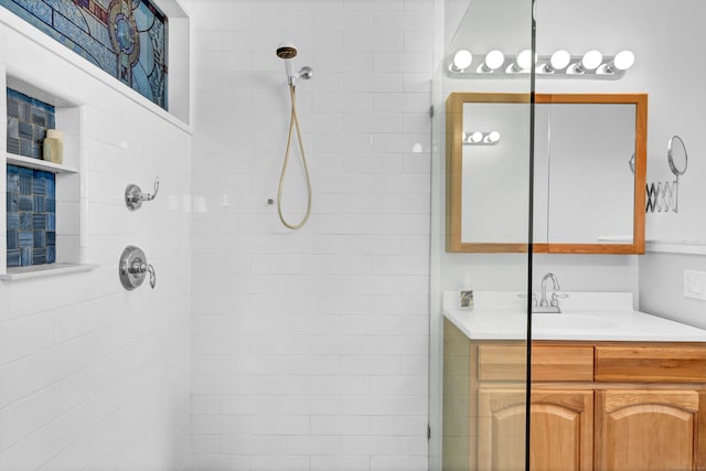 full bath featuring vanity and tiled shower