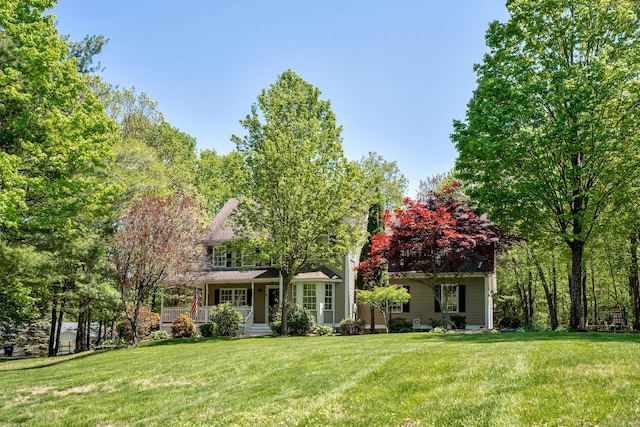 view of front of home featuring covered porch and a front lawn
