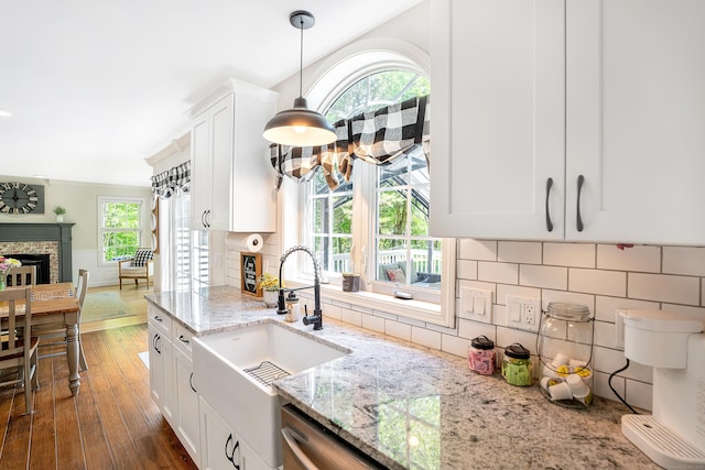 kitchen with a sink, a fireplace, and healthy amount of natural light