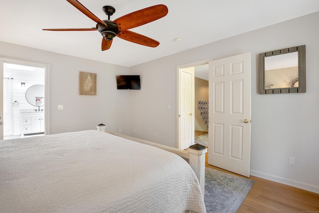 bedroom with baseboards, light wood-style floors, ensuite bath, and ceiling fan