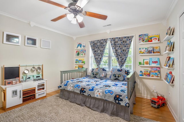 bedroom featuring crown molding, wood finished floors, baseboards, and ceiling fan