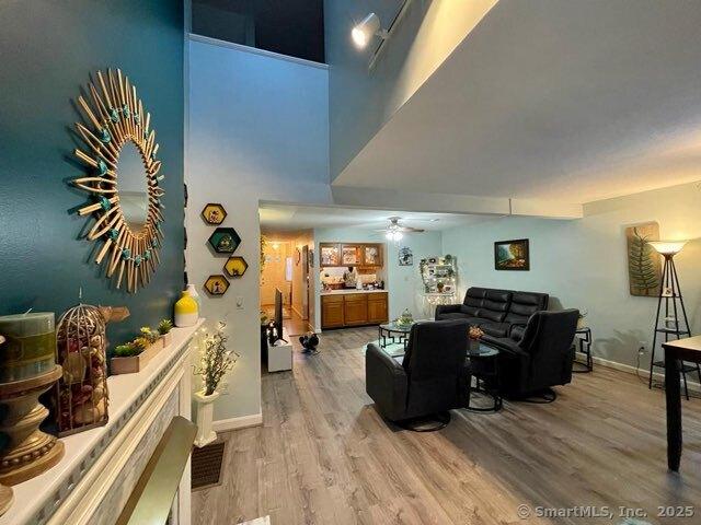 190 Main St Apt D, Manchester, CT 06042 - living room with wood finished floors, baseboards, ceiling fan, and a high ceiling
