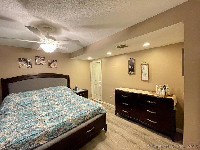 190 Main St Apt D, Manchester, CT 06042 - bedroom featuring light wood-type flooring, a textured ceiling, recessed lighting, a ceiling fan, and baseboards