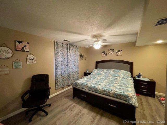 190 Main St Apt D, Manchester, CT 06042 - bedroom with baseboards, light wood finished floors, a textured ceiling, and ceiling fan