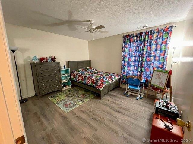 190 Main St Apt D, Manchester, CT 06042 - bedroom featuring wood finished floors, a textured ceiling, and a ceiling fan