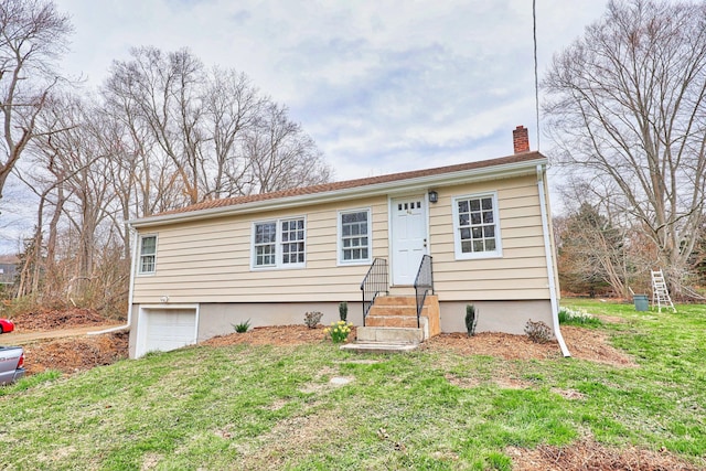 view of front of property with a front lawn, a chimney, entry steps, and an attached garage