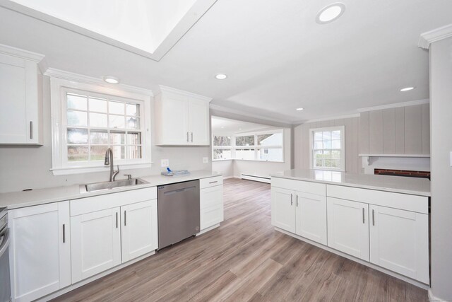 kitchen with a sink, light wood-style flooring, white cabinetry, stainless steel dishwasher, and baseboard heating