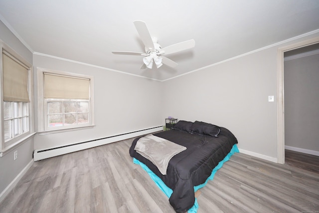 bedroom featuring baseboard heating, baseboards, wood finished floors, and a ceiling fan