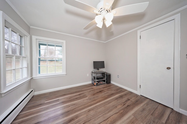 interior space featuring ceiling fan, crown molding, baseboards, wood finished floors, and a baseboard radiator