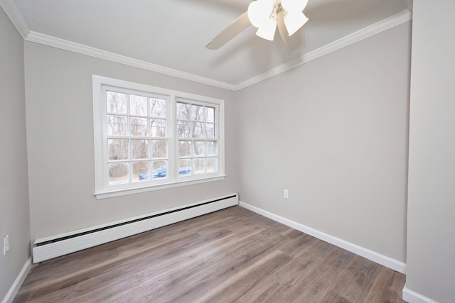 spare room featuring baseboard heating, baseboards, wood finished floors, and crown molding