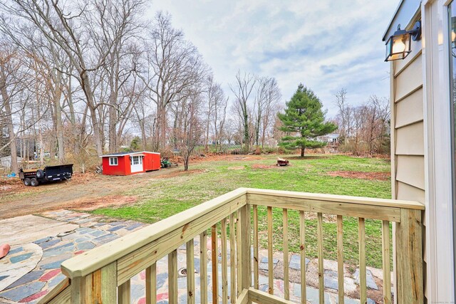 wooden deck featuring an outbuilding and a yard