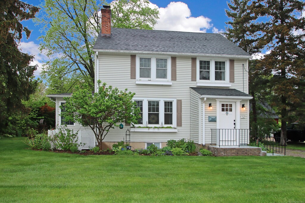 57 Prospect St, Bloomfield, CT 06002 - colonial home featuring roof with shingles, a chimney, and a front yard