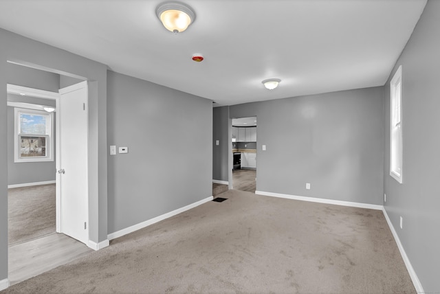unfurnished room featuring baseboards and carpet floors