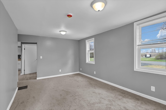carpeted empty room with baseboards and visible vents