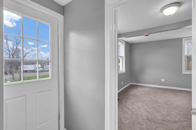 entryway featuring carpet flooring, baseboards, and a healthy amount of sunlight