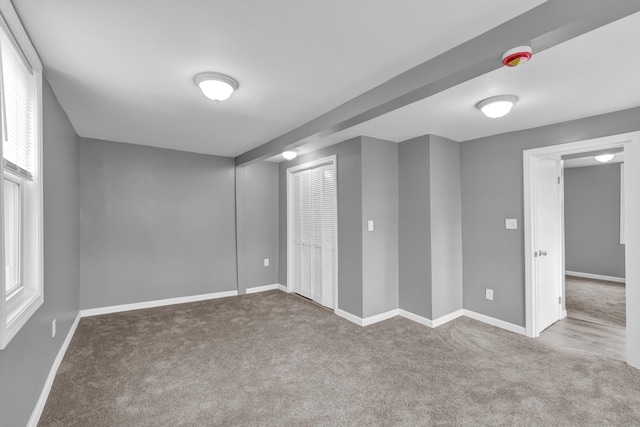 basement featuring baseboards and carpet floors