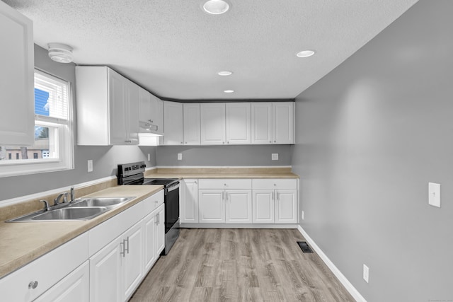kitchen with stainless steel range with electric stovetop, a sink, light wood-type flooring, a textured ceiling, and under cabinet range hood