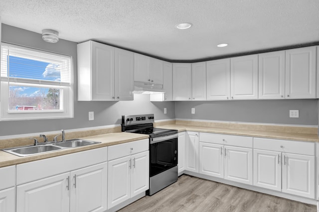 kitchen featuring under cabinet range hood, a textured ceiling, stainless steel electric stove, and a sink