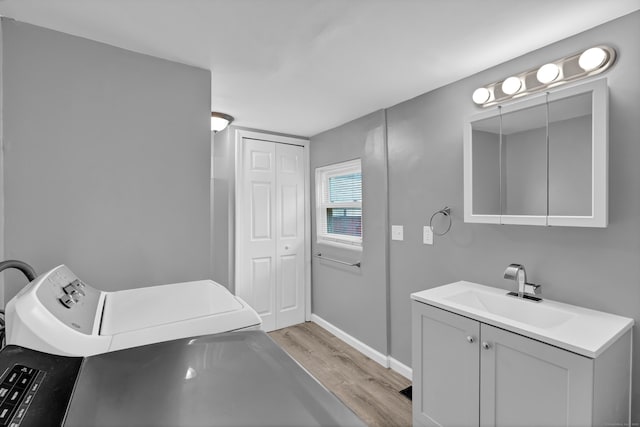 bathroom with vanity, wood finished floors, and baseboards