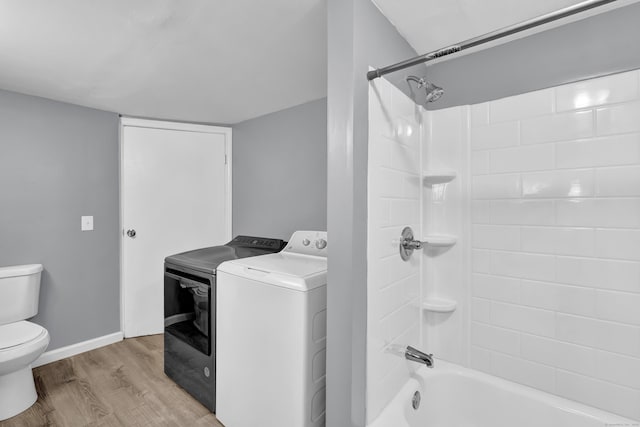 full bath with toilet, baseboards, wood finished floors, and shower / tub combination