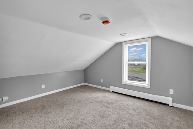 additional living space featuring a baseboard radiator, lofted ceiling, carpet flooring, and baseboards