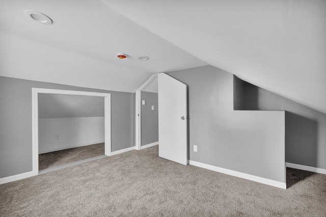 bonus room featuring vaulted ceiling, carpet flooring, and baseboards
