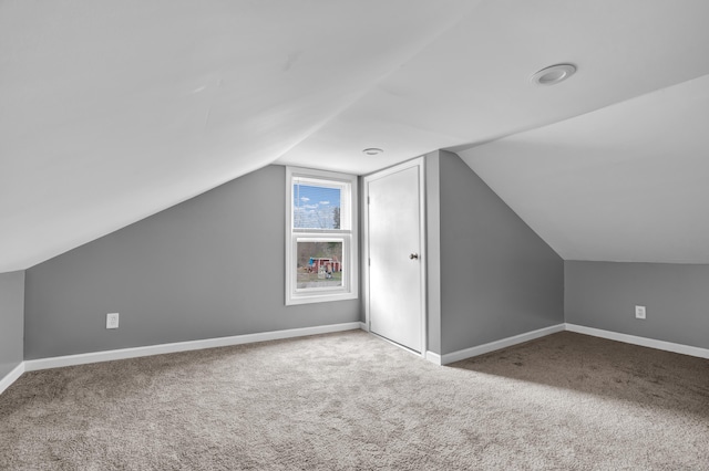 additional living space featuring baseboards, carpet flooring, and vaulted ceiling