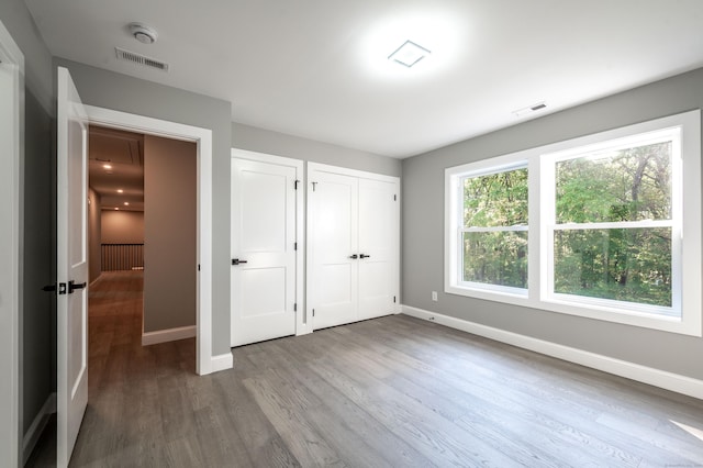 43 Moose Hill Rd, Trumbull, CT 06611 - unfurnished bedroom with baseboards, wood finished floors, and two closets