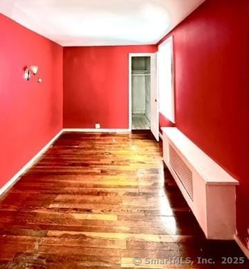 unfurnished bedroom with baseboards and wood finished floors