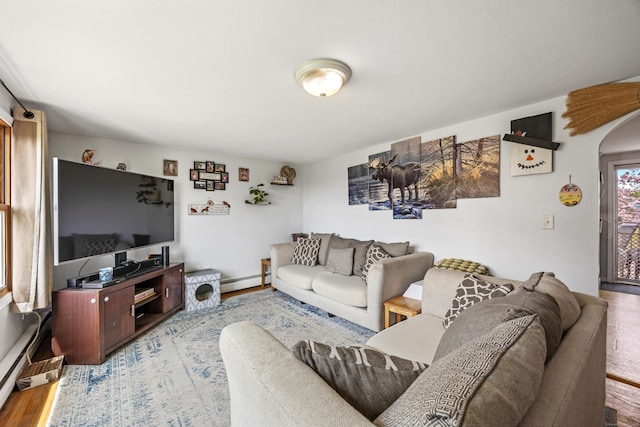 living room with arched walkways, baseboard heating, wood finished floors, and a baseboard radiator