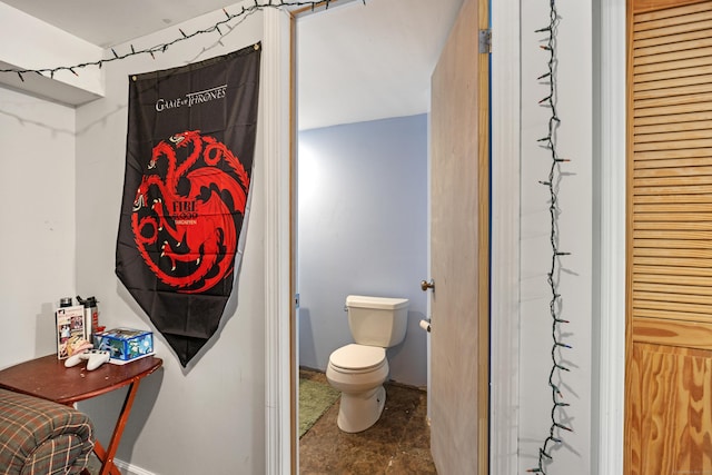 bathroom featuring baseboards and toilet