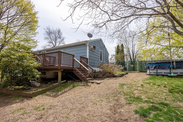 rear view of property featuring fence, stairs, and a wooden deck