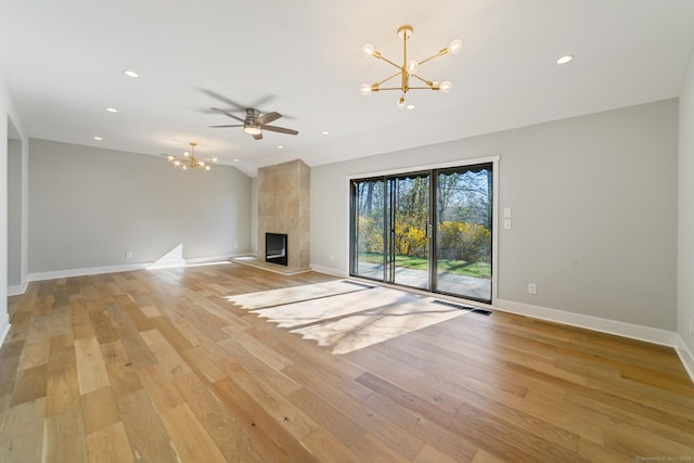 unfurnished living room with recessed lighting, baseboards, ceiling fan with notable chandelier, and light wood-style flooring