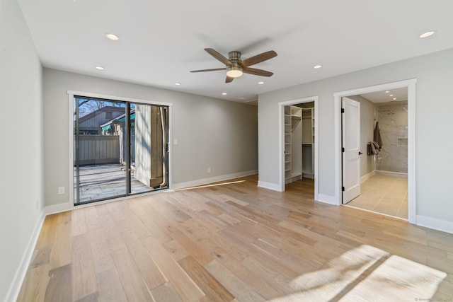 unfurnished bedroom featuring a walk in closet, recessed lighting, access to exterior, and light wood-type flooring