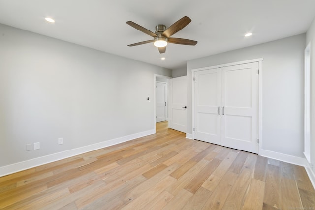unfurnished bedroom with light wood-style flooring, baseboards, recessed lighting, and a closet