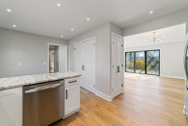 kitchen featuring stainless steel dishwasher, light wood finished floors, white cabinets, baseboards, and a notable chandelier