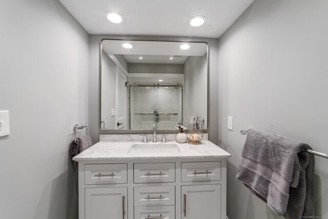 bathroom with a shower stall and vanity