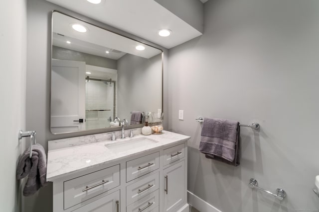 bathroom featuring baseboards, vanity, recessed lighting, and a shower with shower door
