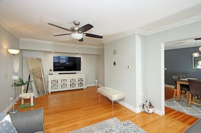 living room with crown molding, a ceiling fan, baseboards, and wood finished floors