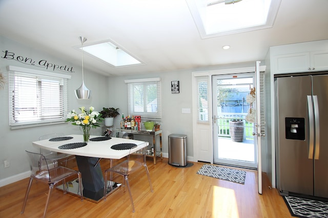 interior space featuring recessed lighting, baseboards, vaulted ceiling with skylight, and light wood-type flooring